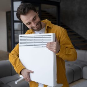 medium-shot-smiley-man-holding-heater